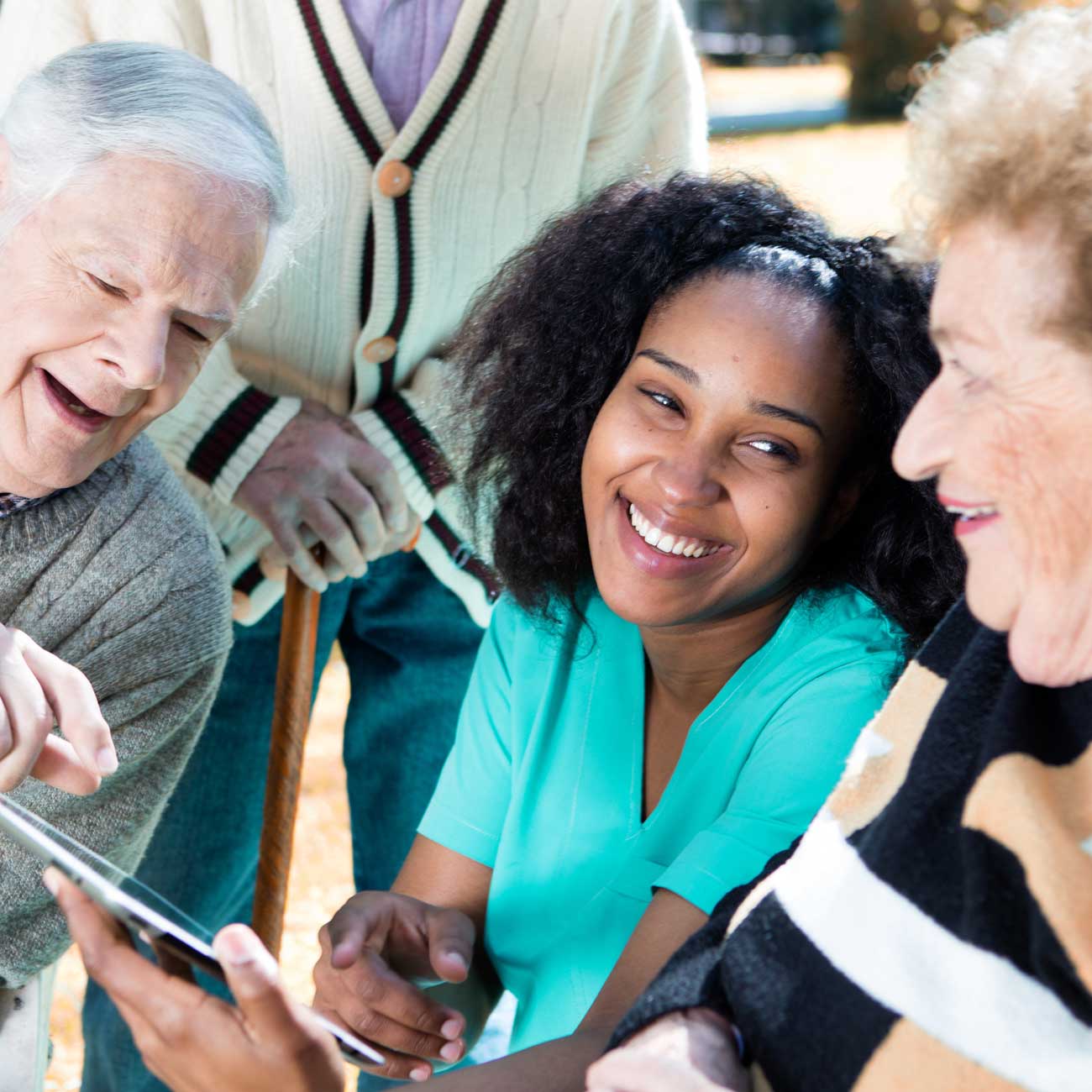 Companion care supervisor showing a tablet screen to senior clients.